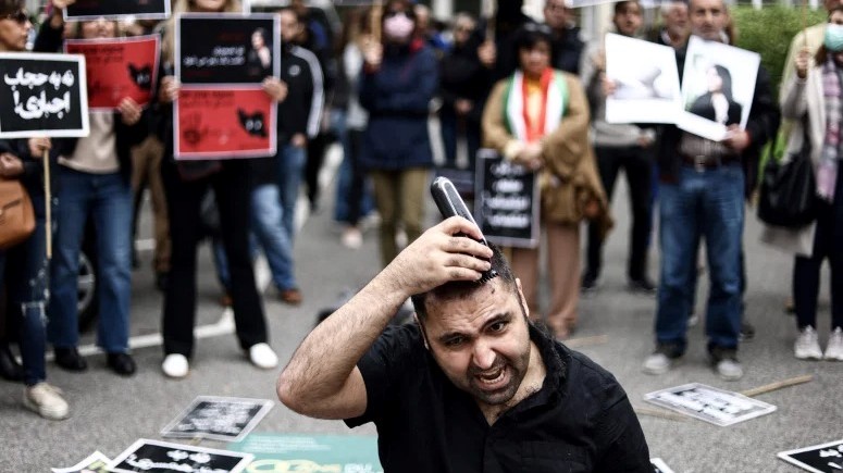 رجل يحلق شعره علنًا خلال تظاهرة أمام السفارة الإيرانية ببروكسل في 23 سبتمبر 2022، تنديداً بمقتل محسا أميني 