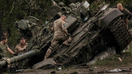 جنود أوكرانيون ينقبون دبابة روسية مهجورة من طراز T-90A في كيريليفكا ، في المنطقة التي تم استعادتها مؤخرًا بالقرب من خاركيف