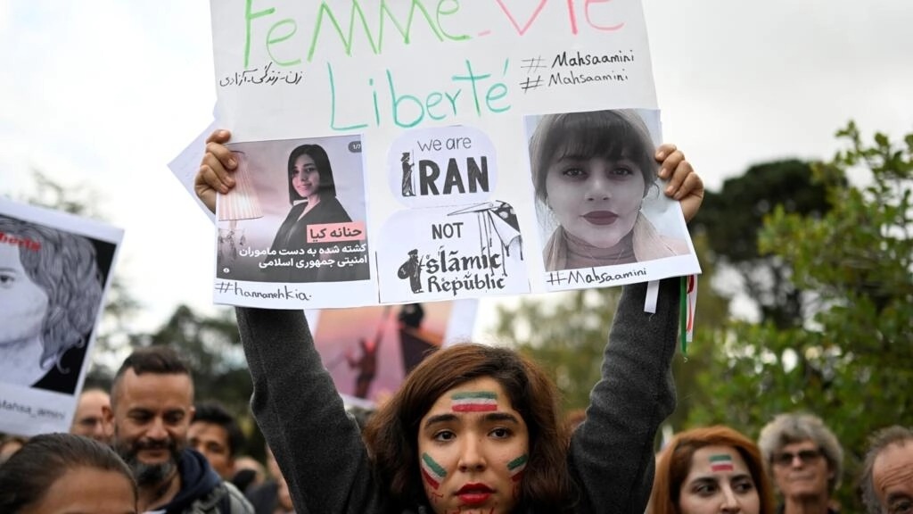 متظاهرة تحمل لافتة دعماً للشابة الإيرانية الكردية مهسا أميني التي توفيت بعد اعتقالها في طهران، خلال تظاهرة في نانت في غرب فرنسا في 3 تشرين الأول/أكتوبر 2022