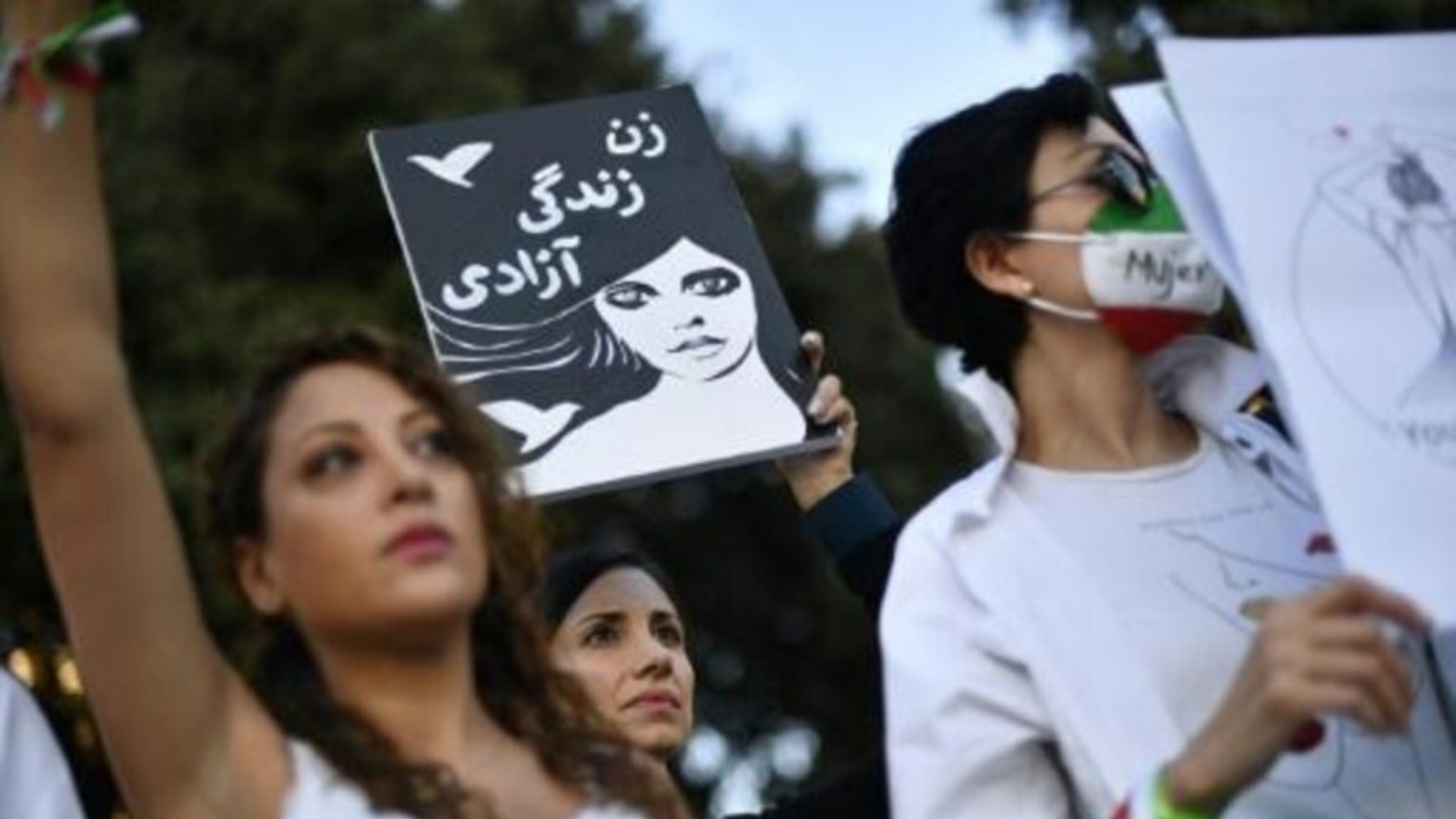 شابة ترفع لافتة كتب عليها بالفارسية 