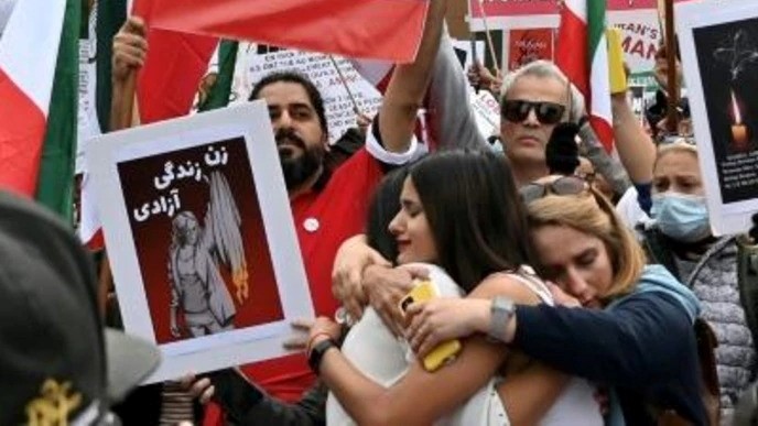  نساء يتعانقن خلال تظاهرة في مونتريال في 1 تشرين الاول/اكتوبر احتجاجا على وفاة مهسا أميني