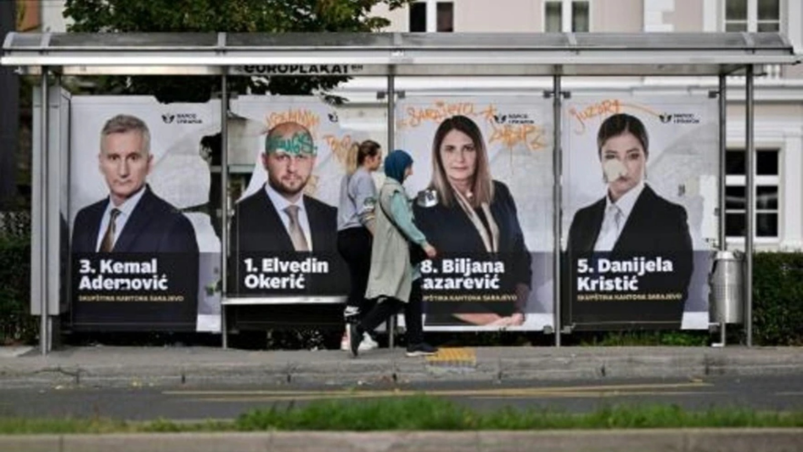 أشخاص يمرّون أمام ملصقات انتخابية في سراييفو في البوسنة، في الأول من أكتوبر 2022