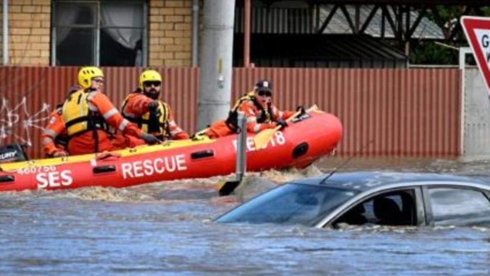 فريق اغاثة ينظر إلى سيارة غمرتها المياه في شارع في كاريبيرنونغ قرب ملبورن في 14 أكتوبر 2022
