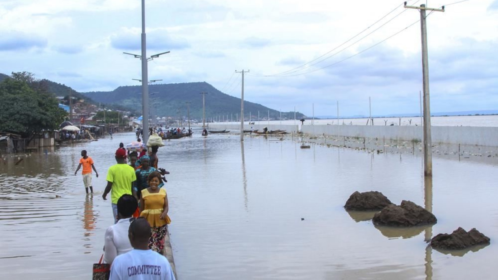 أشخاص تقطعت بهم السبل بسبب الفيضانات من جراء هطول الأمطار في كوجي بنيجيريا (6 ت1 2022، أ ف ب). أشخاص تقطعت بهم السبل بسبب الفيضانات من جراء هطول الأمطار في كوجي بنيجيريا 6 أكتوبر 2022