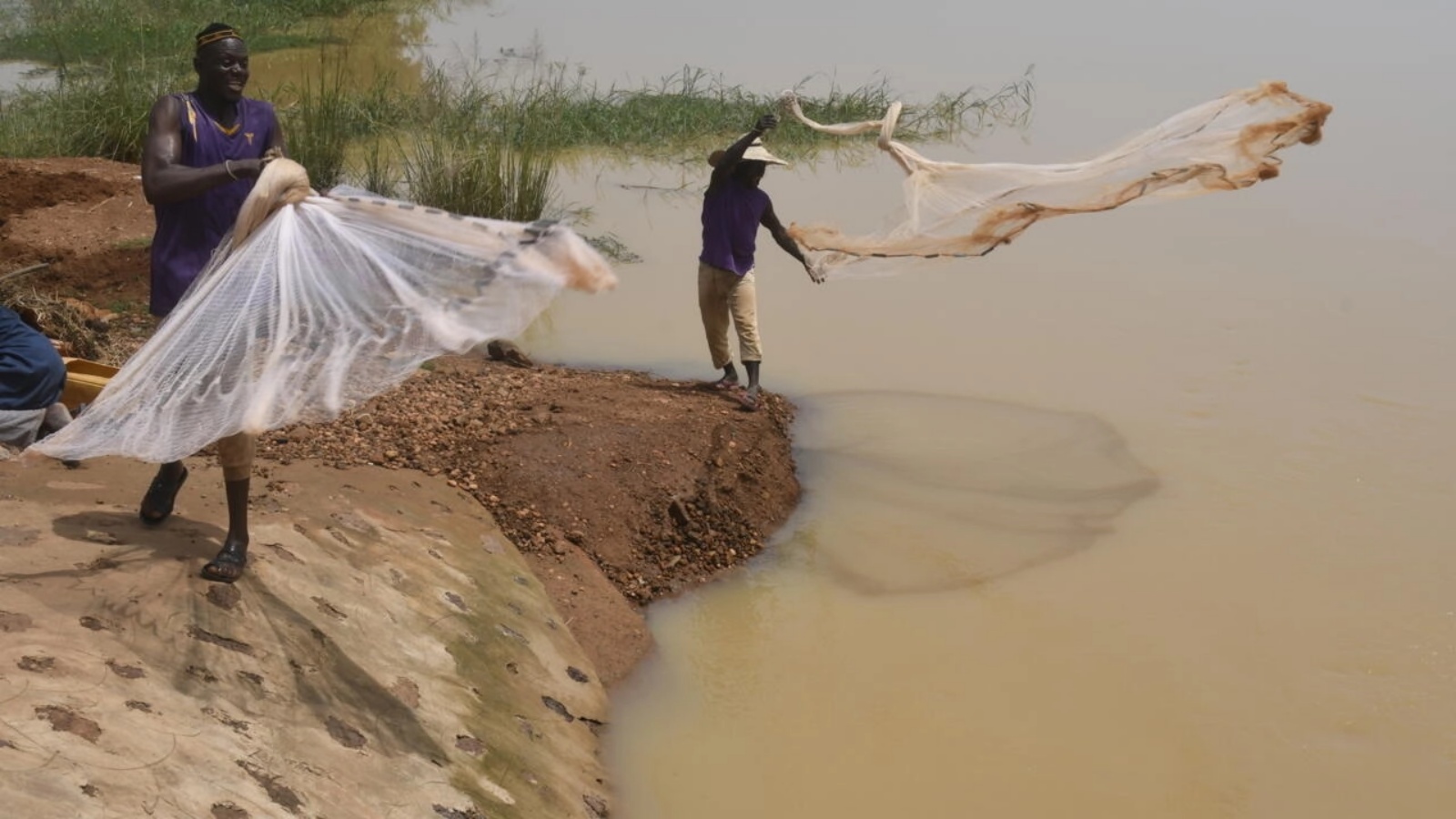 سكان قرية كواتشا يلقون شباك الصيد في نهر النيجر بالقرب من غايا على الحدود بين النيجر وبنين في 9 أكتوبر 2022