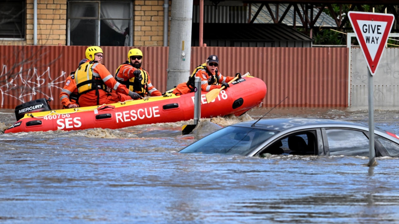 فريق اغاثة ينظر إلى سيارة غمرتها المياه في شارع في كاريبيرنونغ قرب ملبورن في 14 أكتوبر 2022