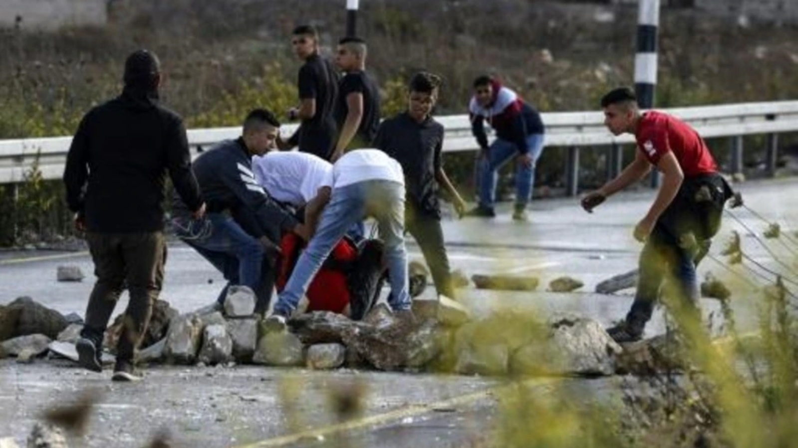 شبان فلسطينيون يجلون متظاهرا أصيب خلال مواجهات مع القوات الإسرائيلية قرب حاجز 