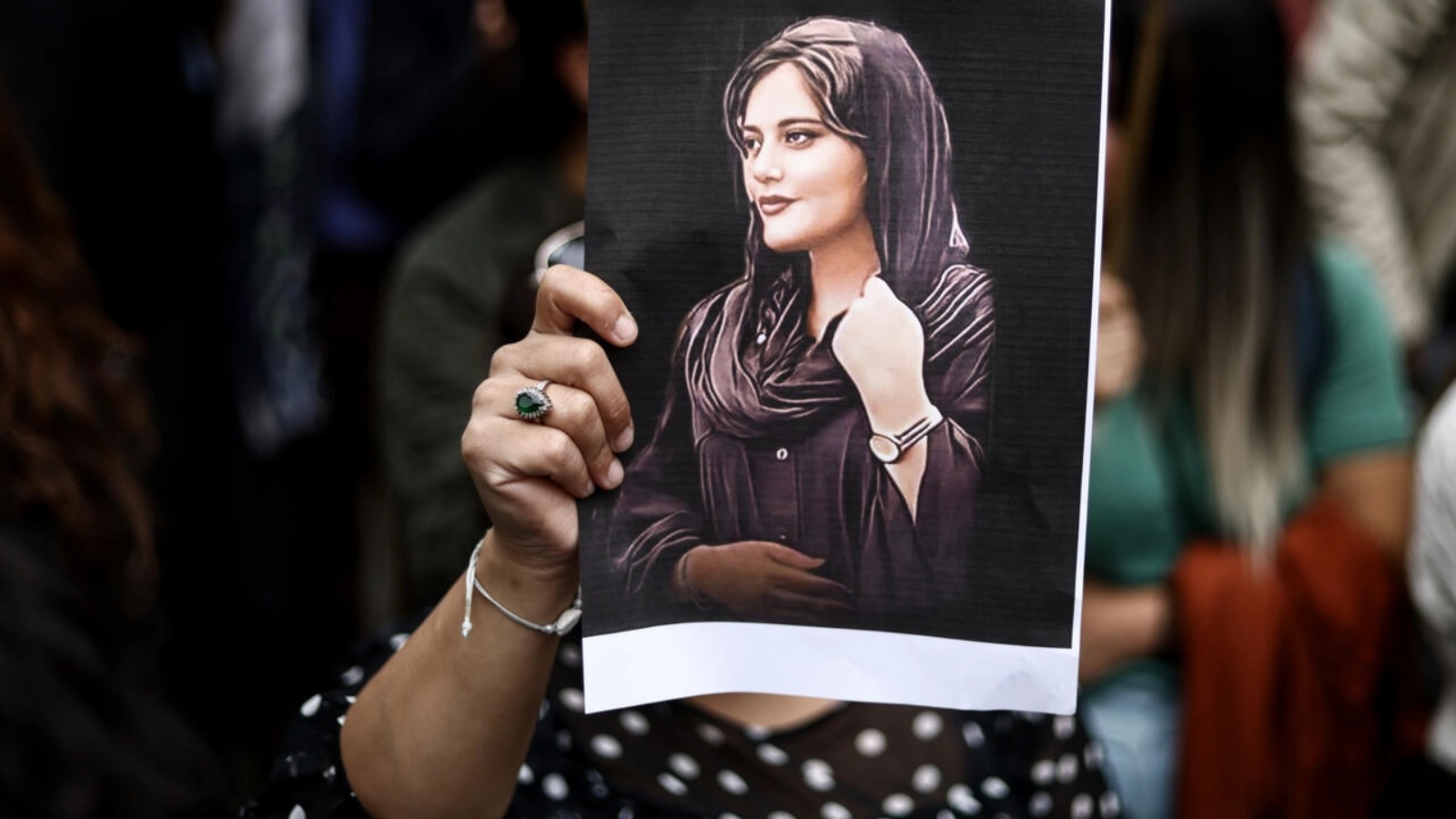 متظاهرة ترفع ضورة مهسا أميني خلال تجمع مؤيد لها أمام مقر السفارة الإيرانية في بروكسل بتاريخ 23 سبتمبر 2022 