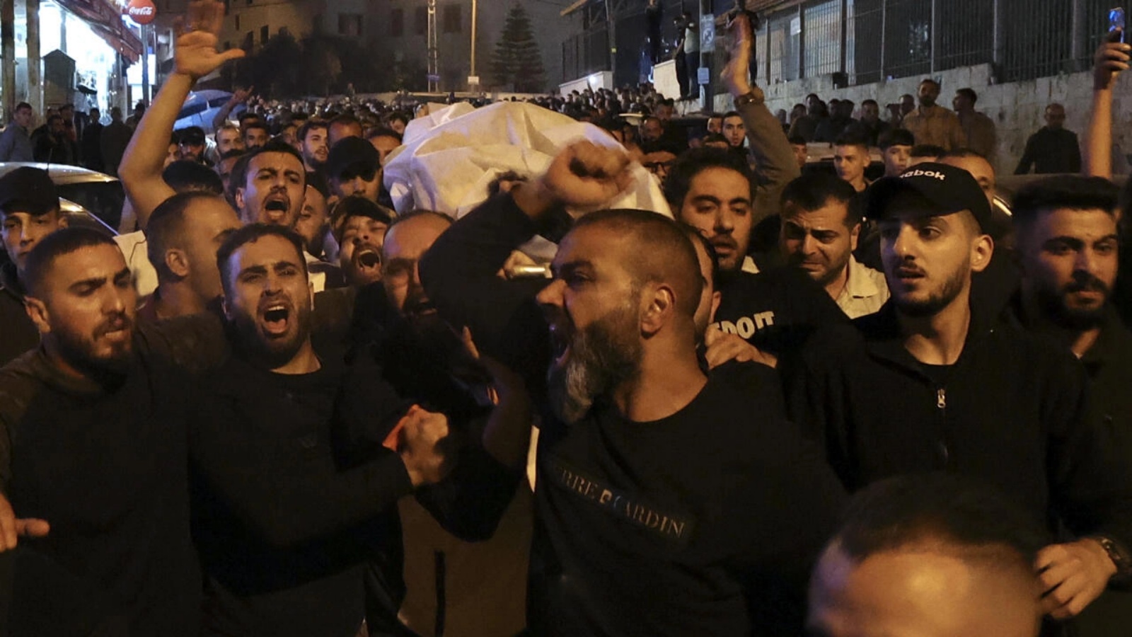 رجال يحملون جثة حمدي شرف الذي قُتل خلال العملية الإسرائيلية ليل الاثنين الثلاثاء في نابلس في الضفة الغربية في 25 أكتوبر 2022