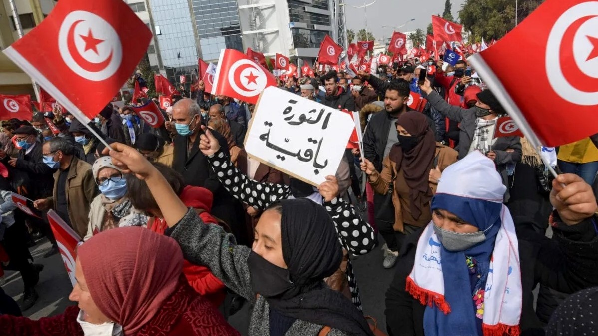 أنصار حزب النهضة الإسلامي يحملون لافتة كتب عليها 'الثورة باقية' خلال مظاهرة مؤيدة للحكومة التونسية في 27 فبراير 2021 في العاصمة تونس