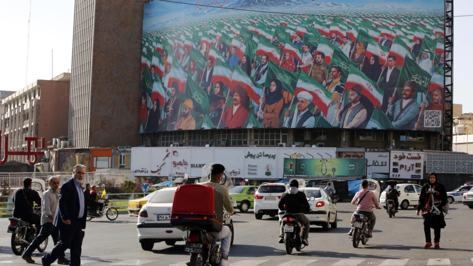 أشخاص يسيرون عبر معبر للمشاة في ساحة وليعصر وسط العاصمة الإيرانية طهران في 25 أكتوبر 2022 