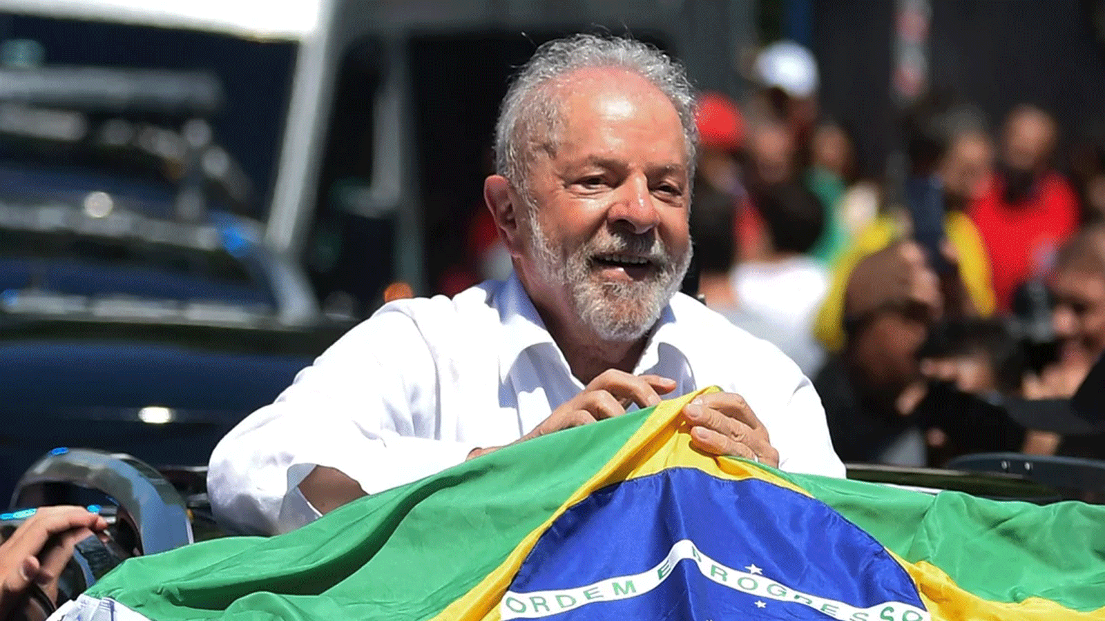 لويز ايناسيو لولا دا سيلفا يحمل العلم البرازيلي أثناء مغادرته إحدى مراكز الاقتراع في ساو باولو خلال الجولة الثانية من الانتخابات الرئاسية يوم الأحد 30 تشرين الأول\ أكتوبر 2022