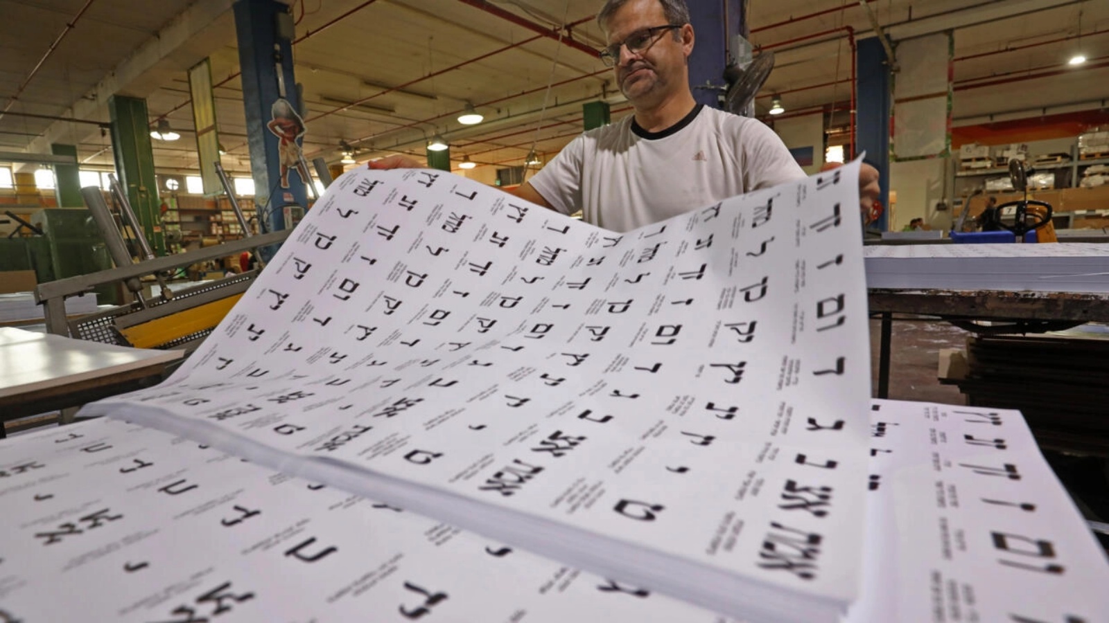 عمال يعدون أوراق الاقتراع في مصنع طباعة في مستوطنة كارني شومرون الإسرائيلية في شمال الضفة الغربية قبل الانتخابات الإسرائيلية في 1 نوفمبر