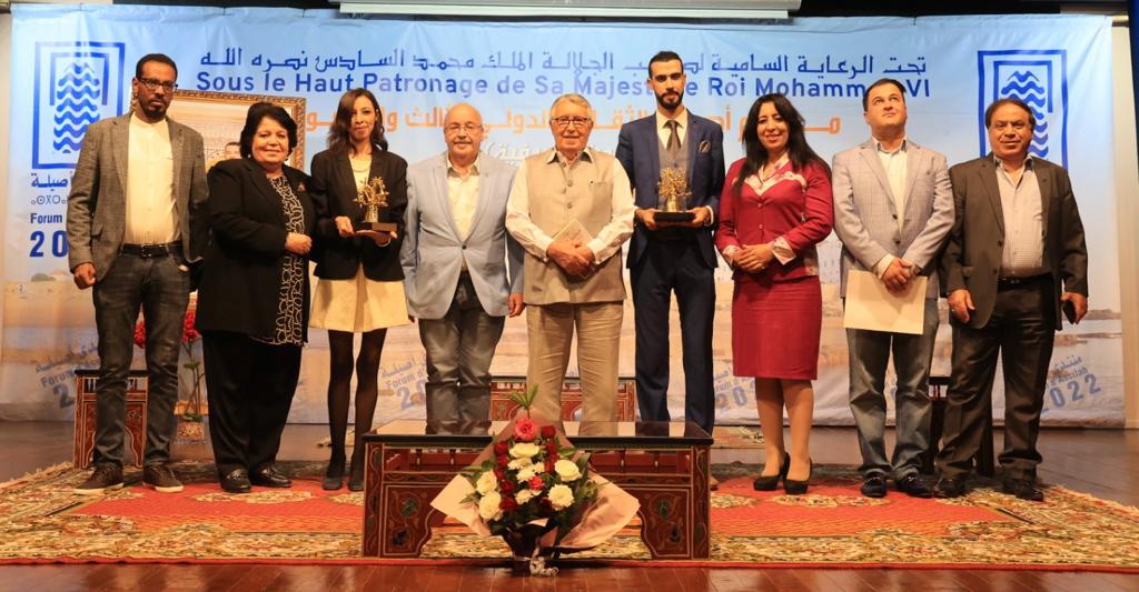 محمد بن عيسى واعضاء لجنة التحكيم في صورة تذكارية مع الشاعرين الفائزين 
