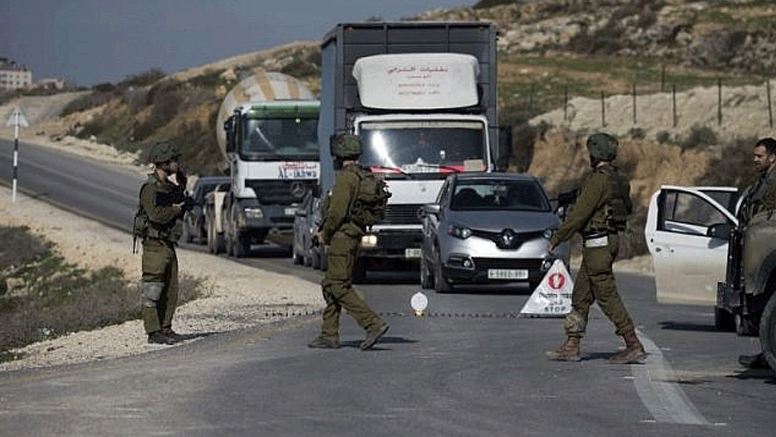 جنود إسرائيليون يتفقدون سيارات عند حاجز بالقرب من مدينة نابلس في الضفة الغربية(أرشيفية)