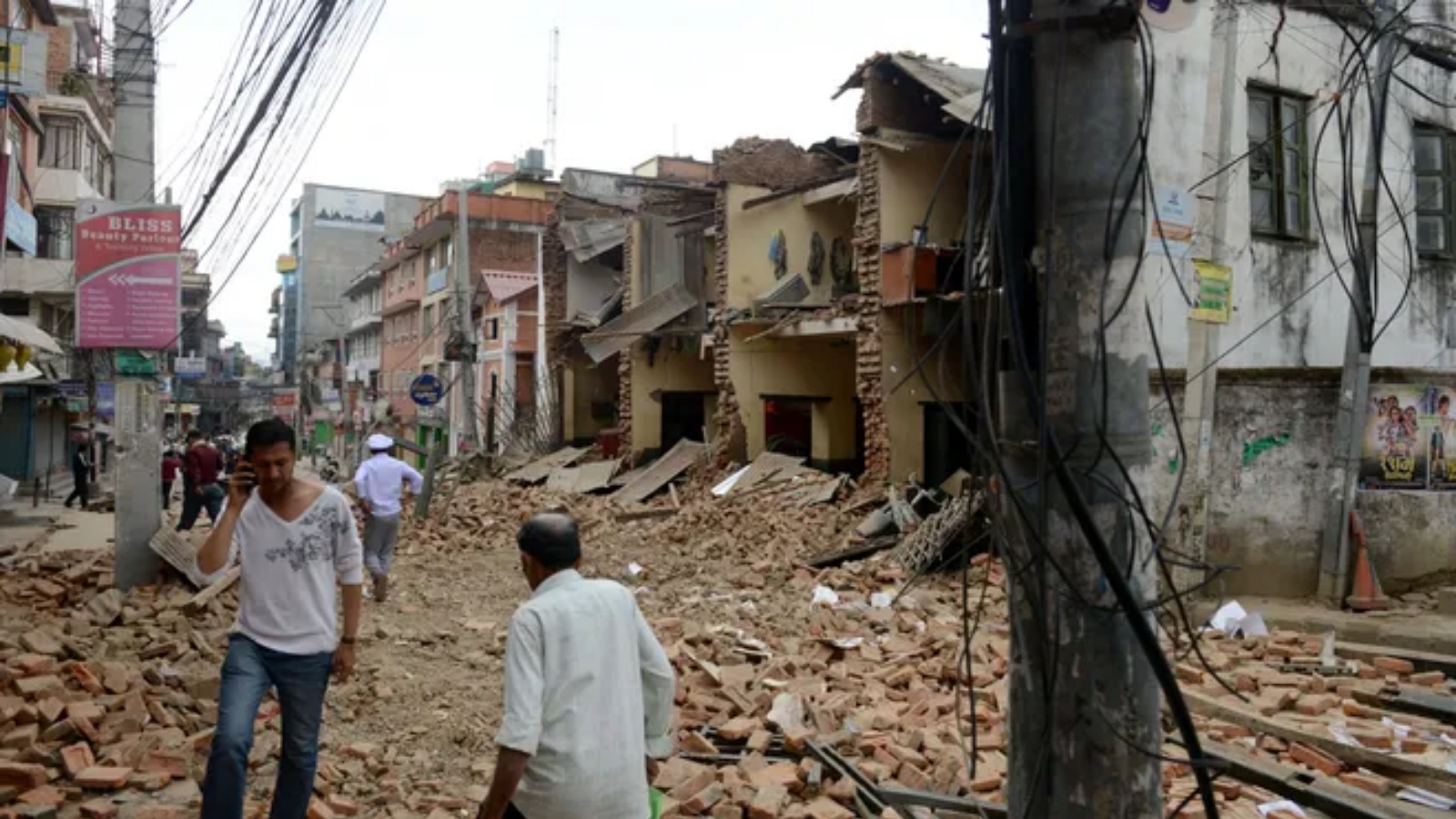 أشخاص فوق أنقاض المنازل المدمرة جراء الزلزال الذي ضرب النيبال (أرشيفية)