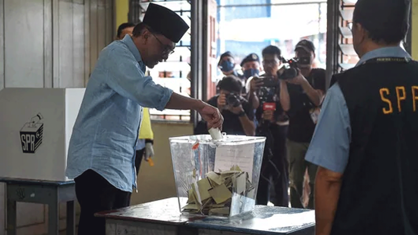  زعيم المعارضة الماليزية، أنور إبراهيم، رئيس باكاتان هارابان (تحالف الأمل) يدلي بصوته في مركز اقتراع خلال الانتخابات العامة في بيرماتانغ باوه.