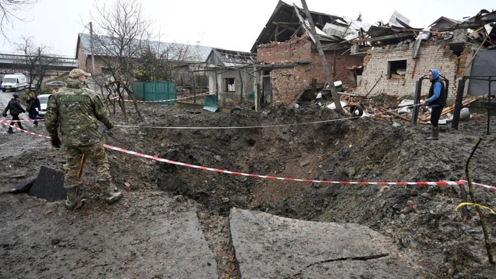 ضباط شرطة يتفحّصون حفرة نتجت عن هجوم صاروخي في لفيف في غرب أوكرانيا في 16 نوفمبر 2022