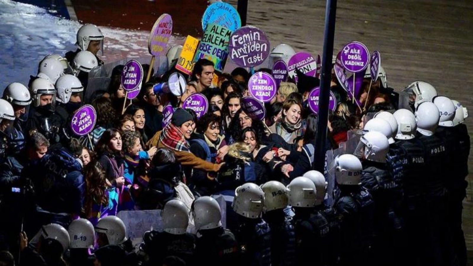 مجموعة من الناشطات لافتة أمام رجال الشرطة في ميدان تقسيم، تركيا 25 نوفمبر 2022