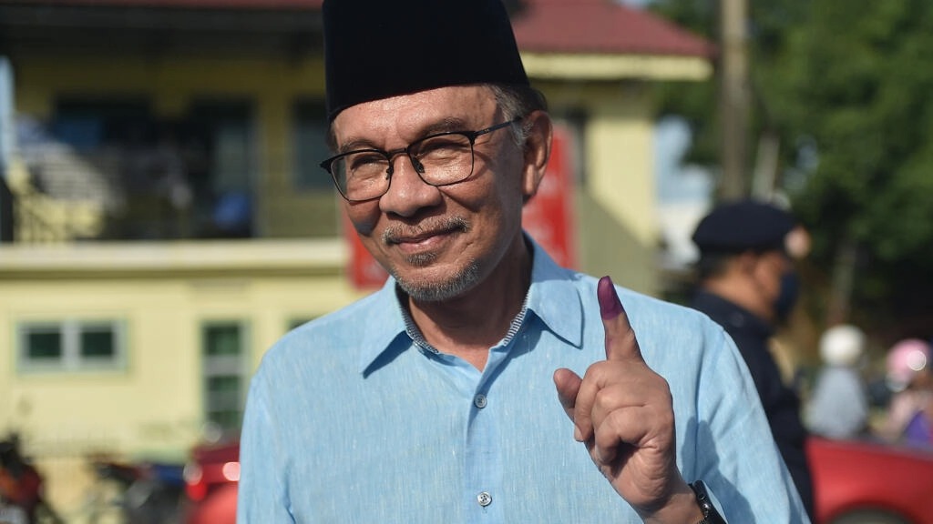 زعيم المعارضة الماليزية أنور ابراهيم يرفع سبابته وعليها آثار حبر بعد الإدلاء بصوته في الانتخابات التشريعية في ولاية بينانغ في 19 نوفمبر 2022
