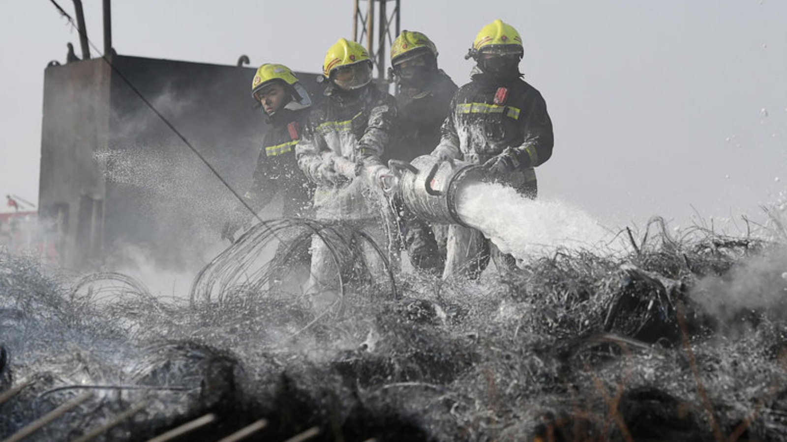 رجال إطفاء يكافحون حريقاً في مصنع في وسط الصين