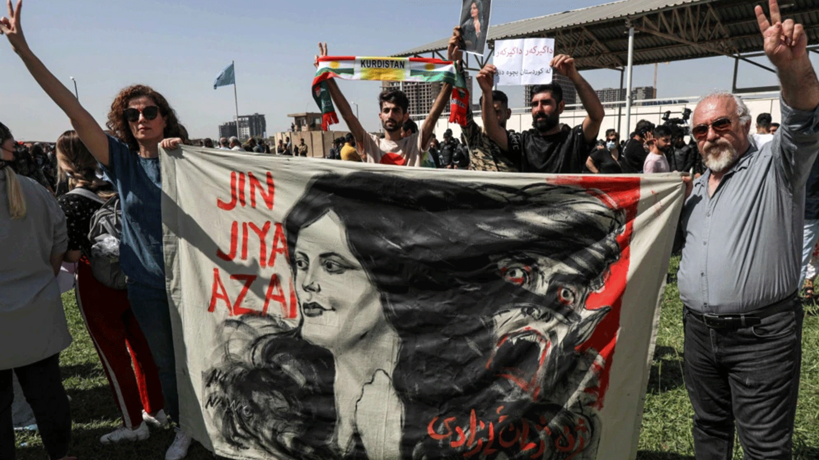 متظاهرون يرفعون لافتة لصورة مهسا أميني التي توفيت أثناء احتجازها لدى السلطات الإيرانية، خلال مظاهرة تندد بوفاتها على يد أكراد عراقيين وإيرانيين خارج مكاتب الأمم المتحدة في أربيل، عاصمة إقليم كردستان 