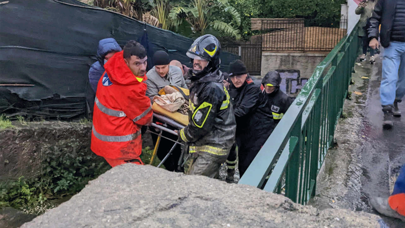 رجال إطفاء إيطاليون ينقلون رجلاً من منزله في 26 تشرين الثاني\نوفمبر 2022 في Casamicciola في جزيرة Ischia الجنوبية ، بعد هطول أمطار غزيرة تسببت في انهيار أرضي.