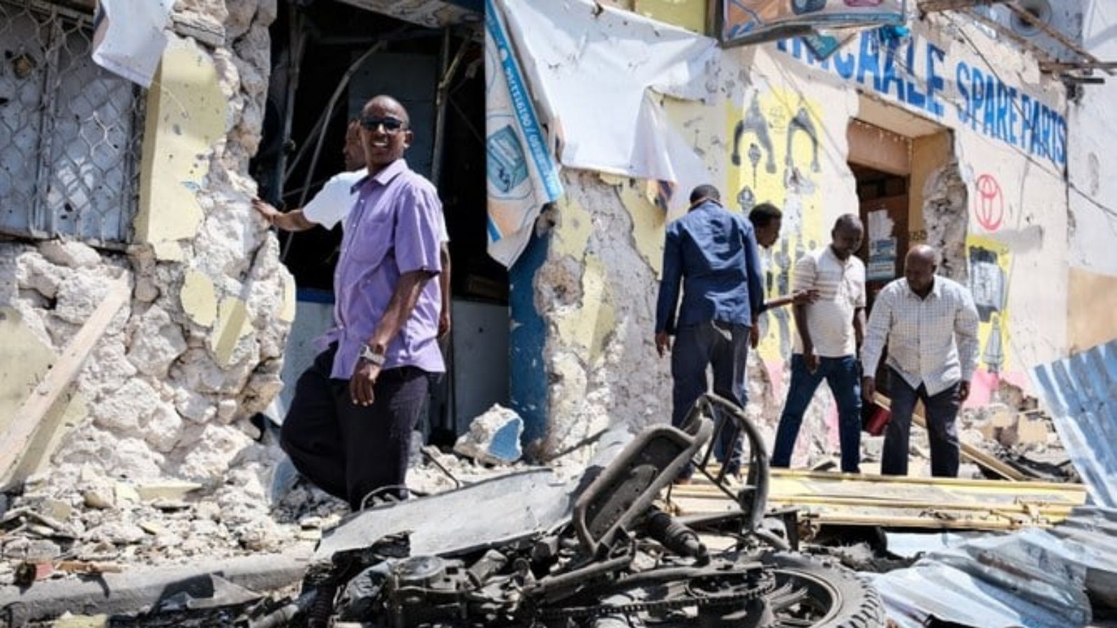 أشخاص يزيلون الأنقاض أمام فندق الحياة المدمر بعد حصار دام 30 ساعة من قبل مسلحي حركة الشباب في مقديشو في 21 أغسطس 2022