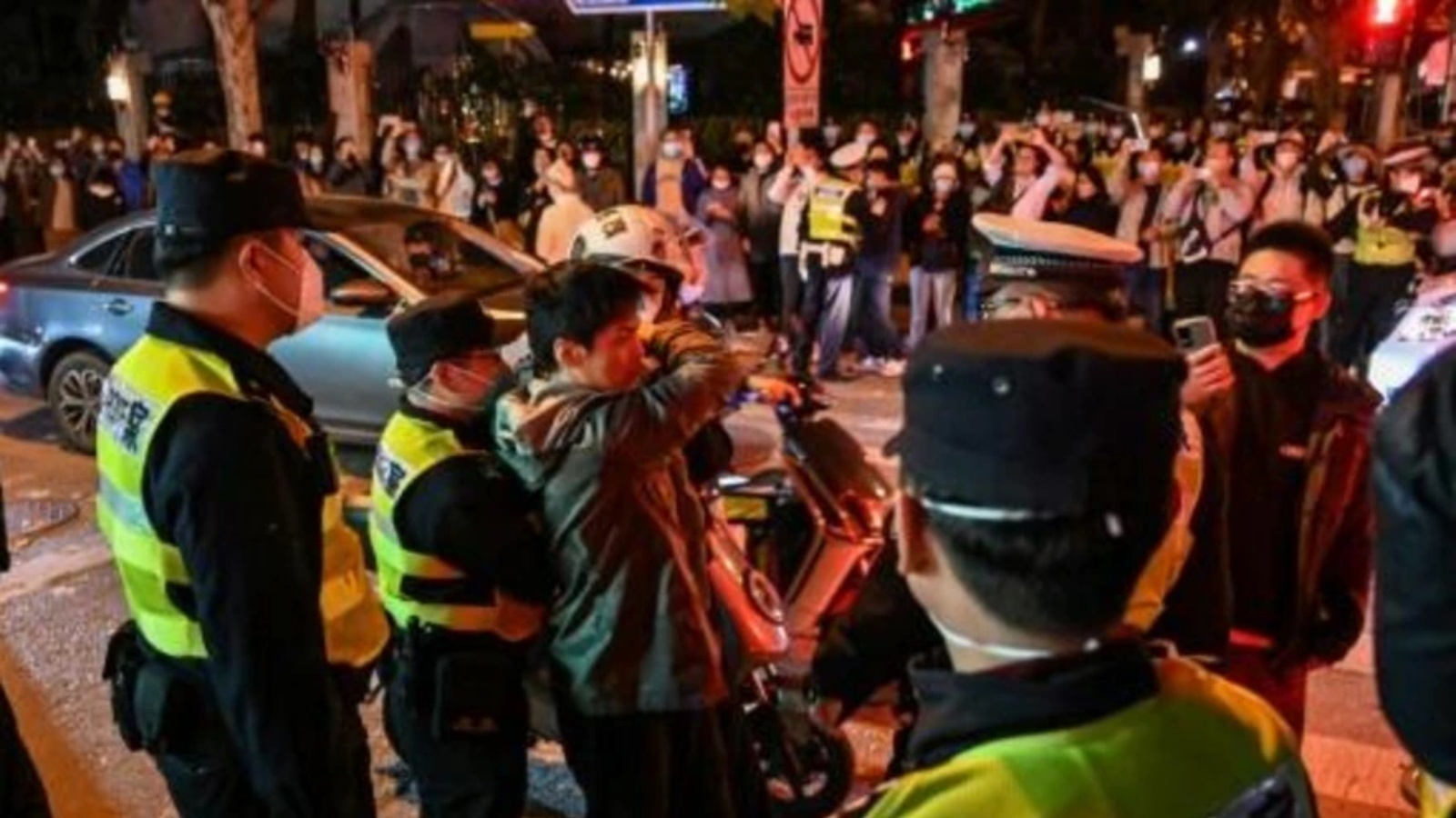 شرطيون يحيطون بمتظاهرين في شارع ولوموتشي خلال تظاهرة ضد السياسة المتبعة لمكافحة كوفيد في 27 نوفمبر 2022 في شنغهاي