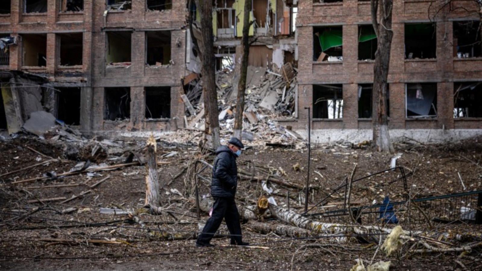 رجل يسير أمام مبنى مدمر بعد هجوم صاروخي روسي بالقرب من كييف