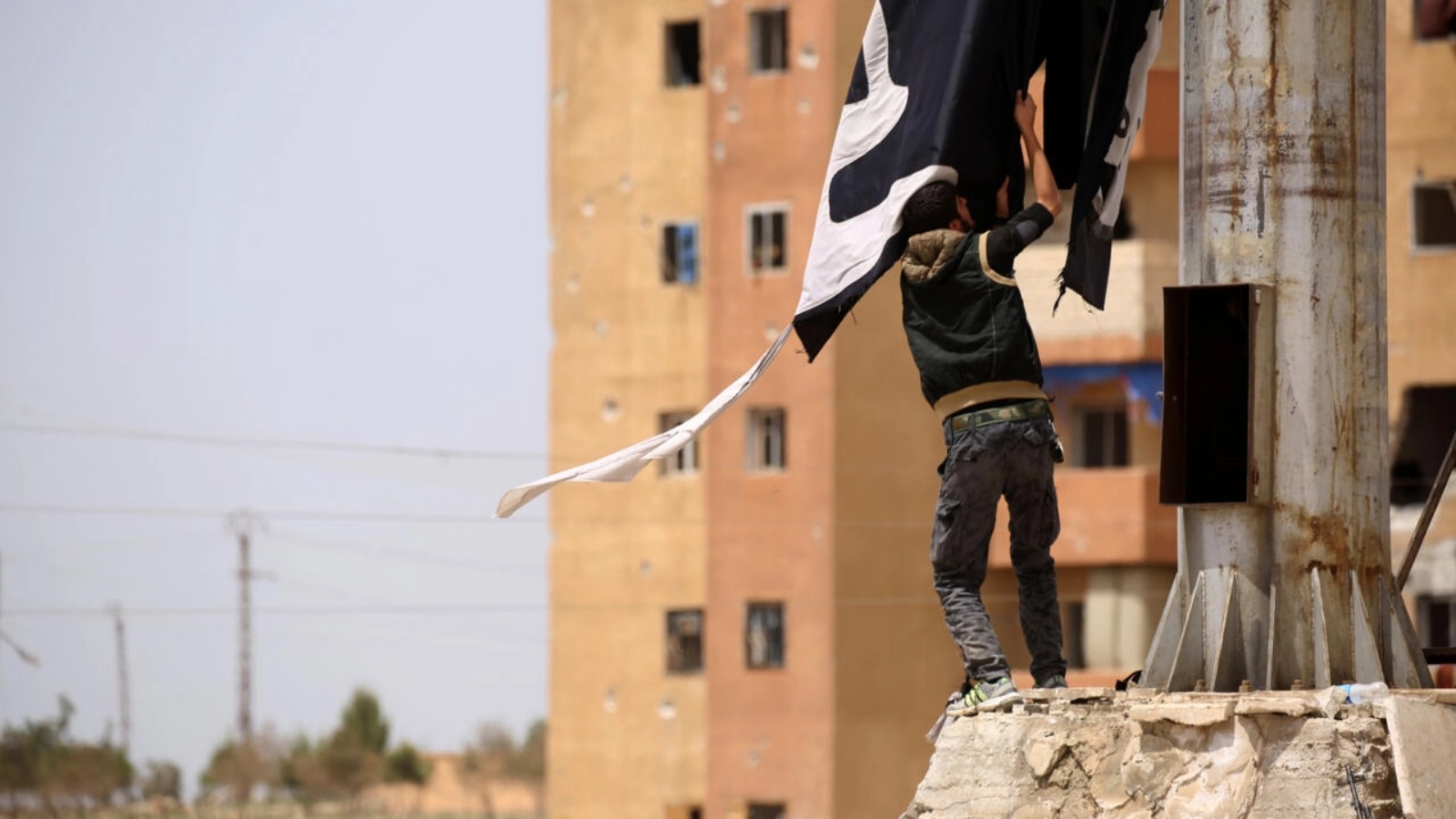 شاب سوري يزيل علم تنظيم الدولة الإسلامية