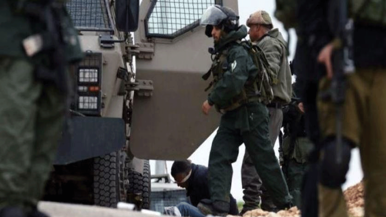 عناصر من الجيش الإسرائيلي يعتقلون شاباً فلسطينياً في رام الله(وفا)