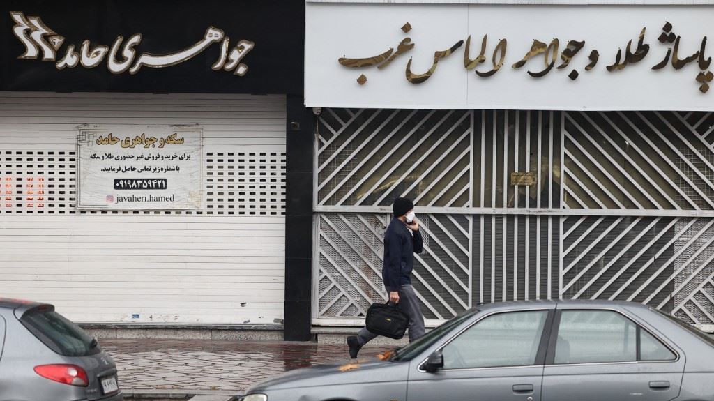 رجل يمر قرب متاجر مغلقة في شارع ساتارخان في طهران في 5 ديسمبر 2022