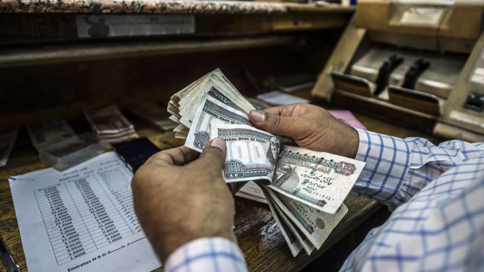 رجل يعد الجنيهات المصرية في محل صرافة بوسط القاهرة