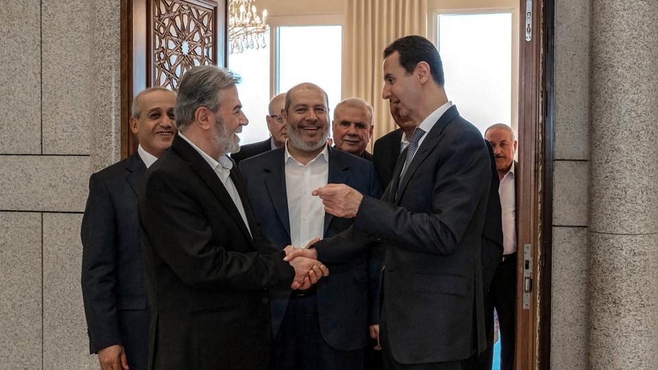 رئيس النظام السوري بشار الأسد (يمين) مستقبلًا مسؤول العلاقات العربية في حماس، خليل الحية (وسط) وآخرين في دمشق، في 19 أكتوبر 2022