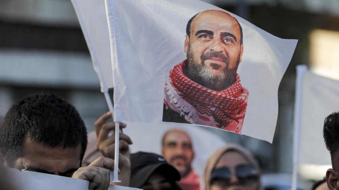 متظاهرون يرفعون صور الناشط الفلسطيني الراحل نزار بنات خلال تظاهرة في الخليل، بالضفة الغربية، في 13 يوليو 2021