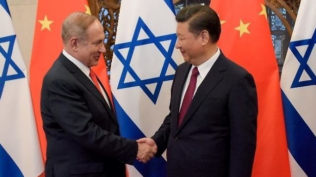 رئيس الوزراء الإسرائيلي بنيامين نتنياهو والرئيس الصيني شي جين بينغ (يمين) يتصافحان قبل محادثاتهما في دار ضيافة دياويوتاي الحكومية في بكين في 21 مارس 2017