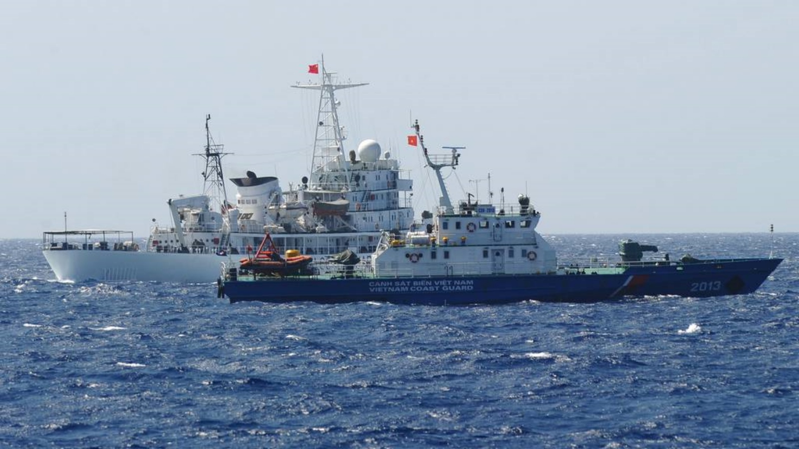 سفينة حرس السواحل الصينية (للخلف) تبحر بجوار سفينة حرس السواحل الفيتنامية (الأمامية) بالقرب من منصة حفر النفط الصينية في المياه المتنازع عليها في بحر الصين الجنوبي (أرشيفية)