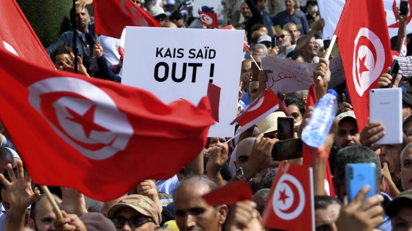أنصار الحزب الدستوري الحر التونسي يلوحون بالأعلام الوطنية ويرفعون لافتات خلال مظاهرة ضد الرئيس قيس سعيد، في العاصمة تونس، يوم 15 أكتوبر 2022