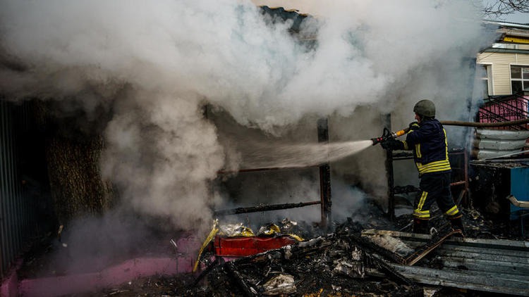 إطفائي يخمد حريقًا في كييف إثر قصف روسي صباحي في 29 ديسمبر 2021