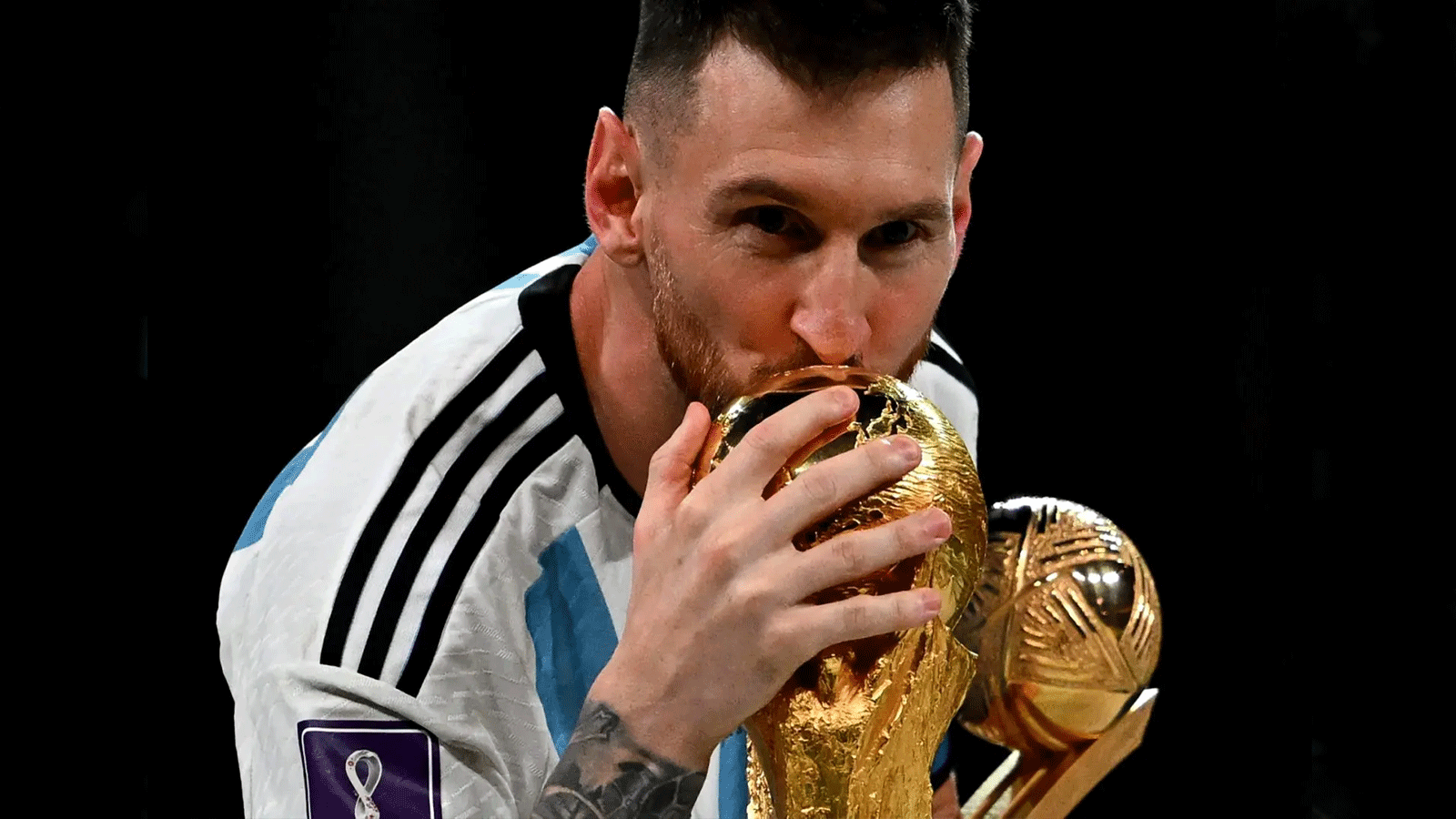 النجم الأرجنتيني ليونيل ميسي يقبّل كأس العالم بعيد فوزه في مونديال قطر