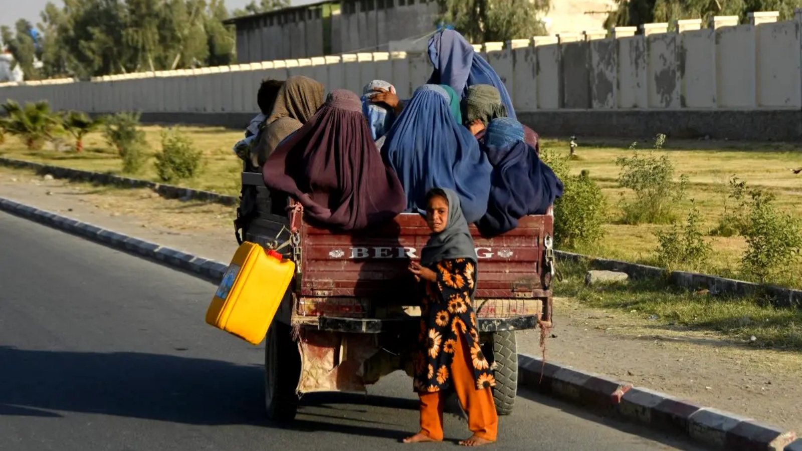 نساء أفغانيات يرتدين البرقع يسافرن في مركبة على طول الطريق في قندهار في 25 ديسمبر 2022