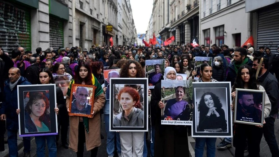 متظاهرون يحملون صور ضحايا إطلاق النار في شارع إنجين في باريس في 23 ديسمبر 2022، وصور جرائم القتل في شارع لافاييت في عام 2013، أثناء مشاركتهم في مسيرة تكريما لهم وتضامنا مع الجالية الكردية في باريس في 26 ديسمبر 2022