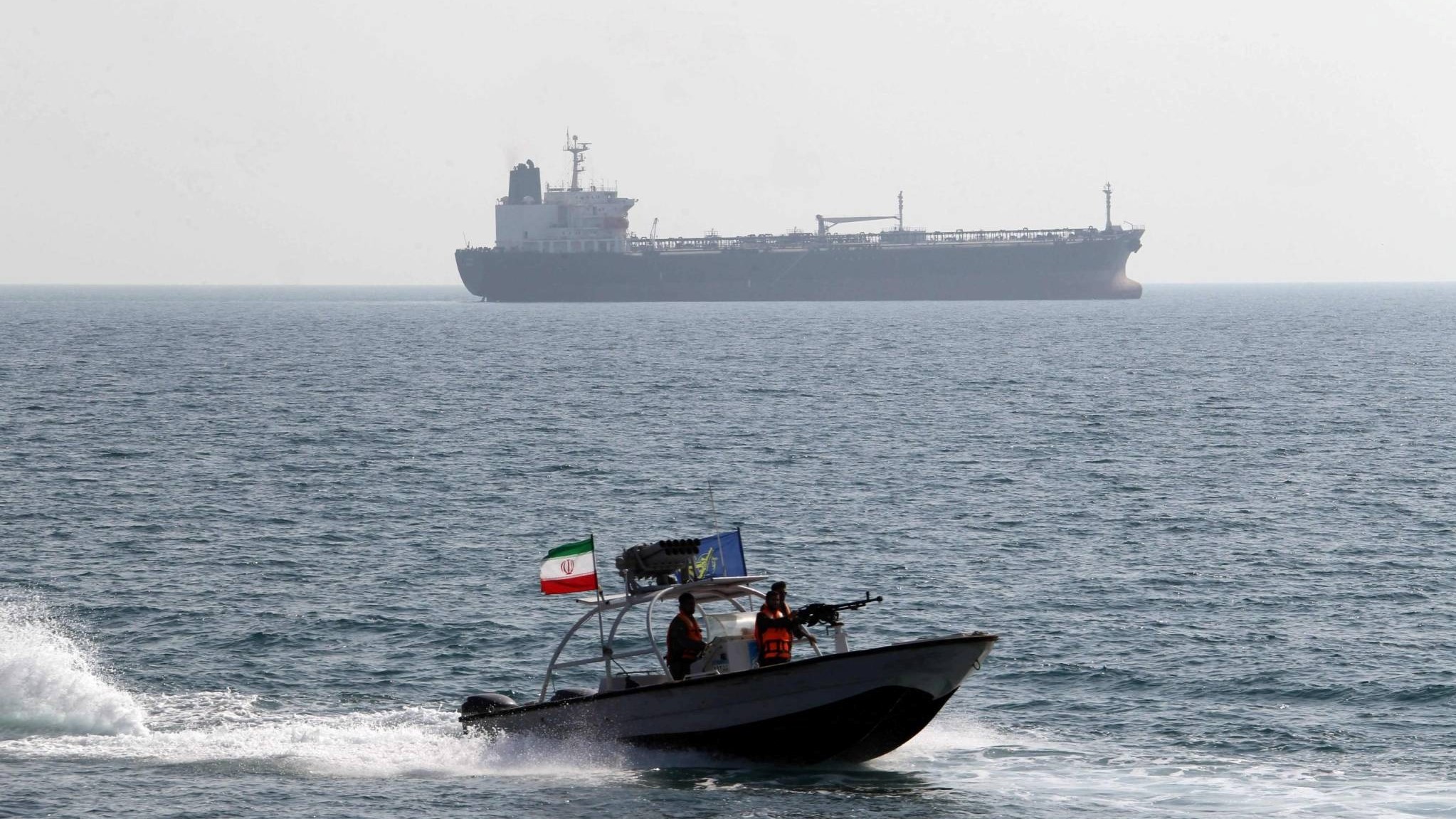 عناصر في الحرس الثوري الإيراني على متن زورق سريع أمام ناقلة نفط في ميناء بندر عباس جنوب إيران
