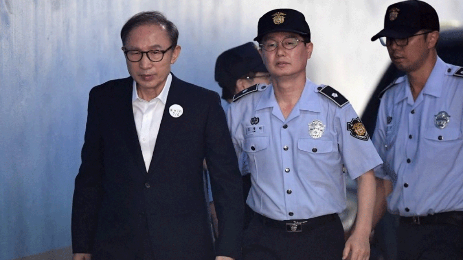 رئيس كوريا الجنوبية السابق لي ميونغ باك (يسار) يصل إلى سيول للمحاكمة في عام 2018