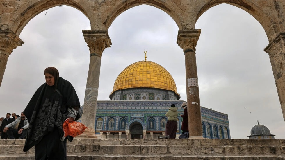 امرأة يظهر خلفها مسجد قبة الصخرة في الأقصى بتاريخ 3 كانون الثاني/يناير 2023