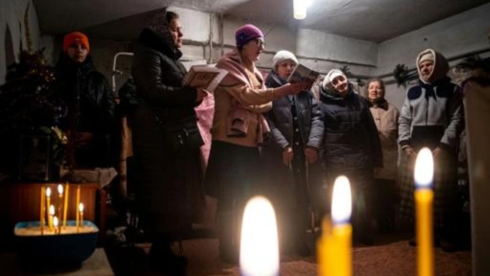 مؤمنون مسيحيون يصلون خلال قداس أرثوذكسي في ملجأ في تشاسيف يار في شرق أوكرانيا في 7 يناير 2023 