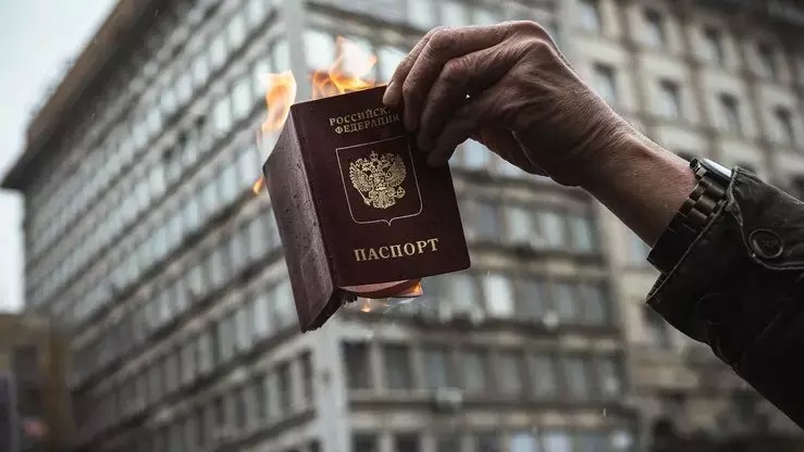 متظاهر يحرق جواز سفره الروسي خلال تظاهرة ضد غزو روسيا لأوكرانيا، في بلغراد