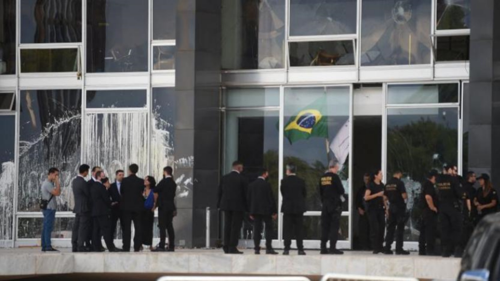 مسؤولون قضائيون وآخرون من الشرطة حارج مبنى المحكمة العليا المتضرر في برازيليا