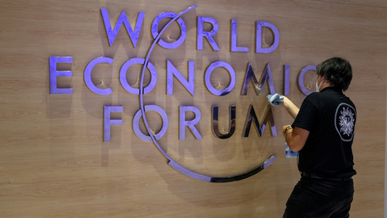  موظفة تنظف شعار المنتدى الاقتصادي العالمي في مركز المؤتمرات في دافوس بسويسرا في 22 مايو 2022